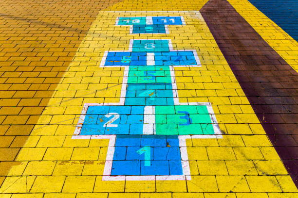 The 3 Benefits of Playground Markings for Schools Bright hopscotch game painted on yellow bricks, perfect for children's outdoor play and fun activities.