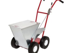 A metal lawn spreader with a red frame and two black rubber wheels, designed for evenly distributing seed or fertilizer.